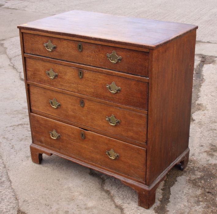 An early 19th century oak chest of four graduated long drawers, on bracket feet, 34" wide