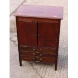 An Edwardian mahogany cupboard, fitted three drawers, on stile supports, 21" wide