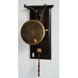 A brass dinner gong on wall hung mount with beater
