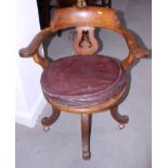 An early 20th century swivel office armchair with panel seat, on four splayed supports with later