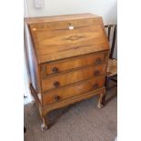 A figured walnut and banded fall front bureau, fitted three drawers, on cabriole claw and ball
