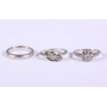 An 18ct white gold and platinum three stone diamond crossover ring, an 18ct white gold, platinum and