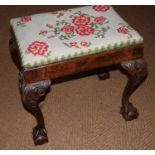 A 19th century carved walnut dressing stool with needlepoint drop-in seat, on cabriole claw and ball