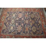 A Hamadan style rug with floral design on a blue ground and multi-bordered in shades of rust,