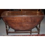 A 19th century oak oval drop leaf gate leg dining table, on turned supports, 55" long