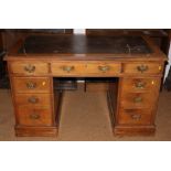 A late 19th century walnut double pedestal desk with tool lined top, fitted nine drawers, on block