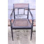 A pair of turned as bamboo ebonised cane seat carver chairs, on turned supports