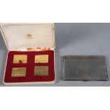 A set of four silver gilt railway stamp replicas, in case, and a silver cigarette case