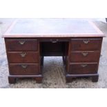 A Georgian mahogany flap top desk fitted drawers and cupboards on square taper supports 44" wide