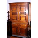 An early 19th century Welsh oak food cupboard with bog oak inlay, the upper section enclosed two