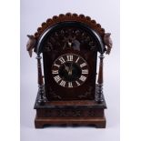 A 19th century carved oak arch top cased cuckoo clock with fusee movement, 21" high