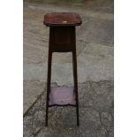An Edwardian mahogany and inlaid jardiniere stand, on square supports united by an undertier