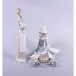 A Lladro figure of a girl holding a lamb and another figure of a girl and ducks