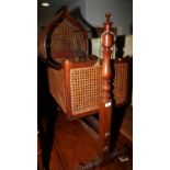 A 19th century mahogany framed cradle with caned sides and hood, on mahogany stand