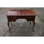 A figured walnut and banded lowboy of Queen Anne design with axe head handles, on cabriole supports,