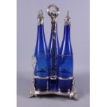 A late Victorian silver plate three-bottle cruet stand, the blue glass bottles applied with silver