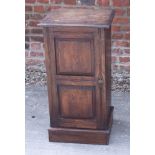 A dark stained oak bedside cabinet enclosed twin panel door