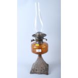 An amber cut glass reservoir oil lamp cast iron stand, 14" high