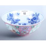 A Chinese porcelain bowl decorated four foliate reserves on a pink ground, the inside decorated in