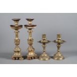 A pair of Indian brass candlesticks, cast with Arabic pattern on circular plinth bases, 9" high,