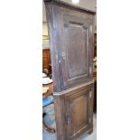 A Georgian oak corner cupboard enclosed two panelled doors, on bracket feet, 27" wide