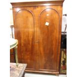 A mid 20th century mahogany two door wardrobe enclosed two arch panel doors, 50" wide