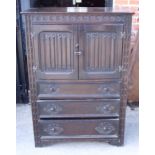 A 17th century design oak tallboy, decorated linenfold carving, fitted cupboard and three drawers