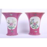 A pair of Chinese porcelain trumpet vases, each decorated with two floral reserves on a pink