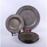 An 18th century pewter plate with wide rim, 9 1/2" dia (restored), seven other pewter plates, 9 1/2"
