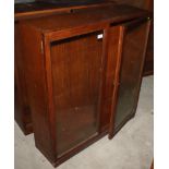 A teak bookcase with adjustable shelves enclosed two glazed doors, 36" wide