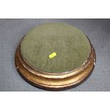 A 19th century circular footstool with gilt frame, on bun feet, 12" dia