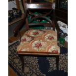 A Regency mahogany open armed carver, upholstered in a needlepoint, on sabre supports