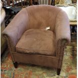 A tub armchair, upholstered in a brown nailed suede