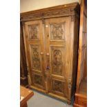A late 19th century stripped pine armoire enclosed two carved doors and split turned columns, on bun
