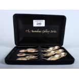 A cased set of six gilt metal spoons with finials decorated Australian birds