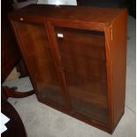 A teak bookcase with adjustable shelves enclosed two glazed doors, 36" wide