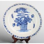 A late 18th century tin glazed Delftware charger, decorated with basket of flowers within a