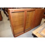 A teak bookcase with adjustable shelves enclosed two glazed doors, 36" wide