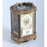 A French early 20th century brass and four-glass carriage clock with carrying handle, on turned