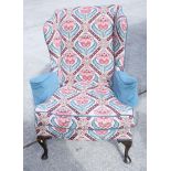 A wing armchair with needlework upholstery, a companion with printed cover and a matching stool