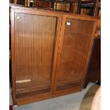 A teak bookcase with adjustable shelves enclosed two glazed doors, 36" wide