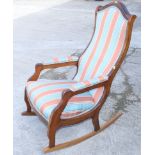 A 20th century walnut rocking chair, upholstered in a striped fabric (one rocker replaced)