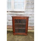 A 19th century mahogany corner cabinet enclosed Gothic arch lattice glazed panel door, on bracket