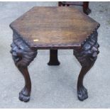 An oak hexagonal coffee table, on tripod supports carved as lion's heads and paws, 21" wide