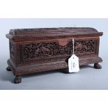An Indian wooden domed top box, the tops and sides intricately carved with animals and scrolls, on
