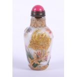 A 19th century Chinese glass snuff bottle with relief decoration and pink hardstone mounted spoon,