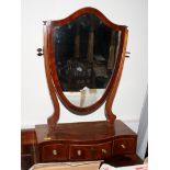 A Georgian mahogany shield-shaped dressing table mirror with serpentine front fitted three