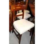 A set of four early 19th century mahogany dining chairs with broad shoulder boards, inlaid stringing