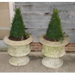A pair of composite stone garden urns, decorated bows and swags, 23" high