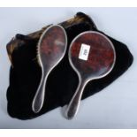 A tortoiseshell and silver backed hair brush, a matching hand mirror and a faux tortoiseshell framed